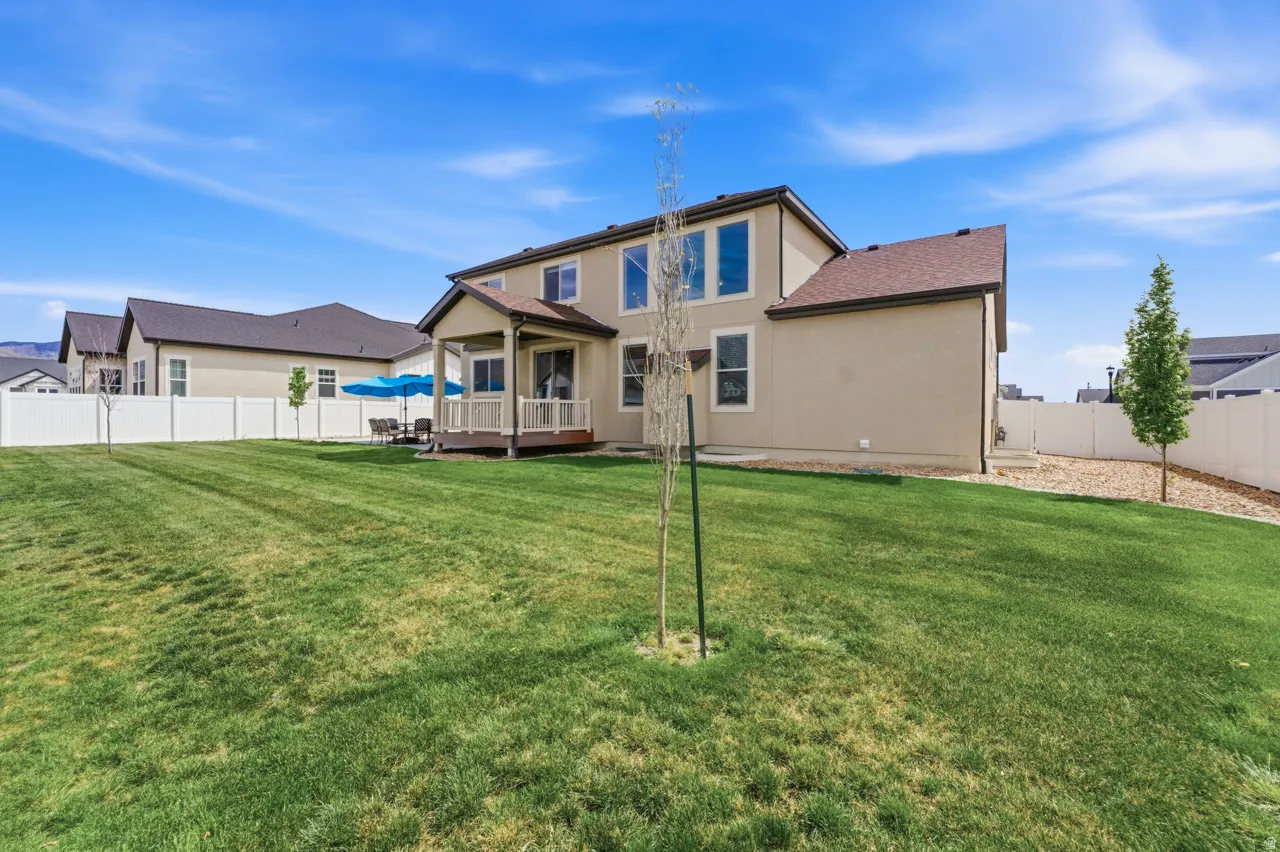 Back of house featuring a wooden deck, a fenced backyard, and stucco siding