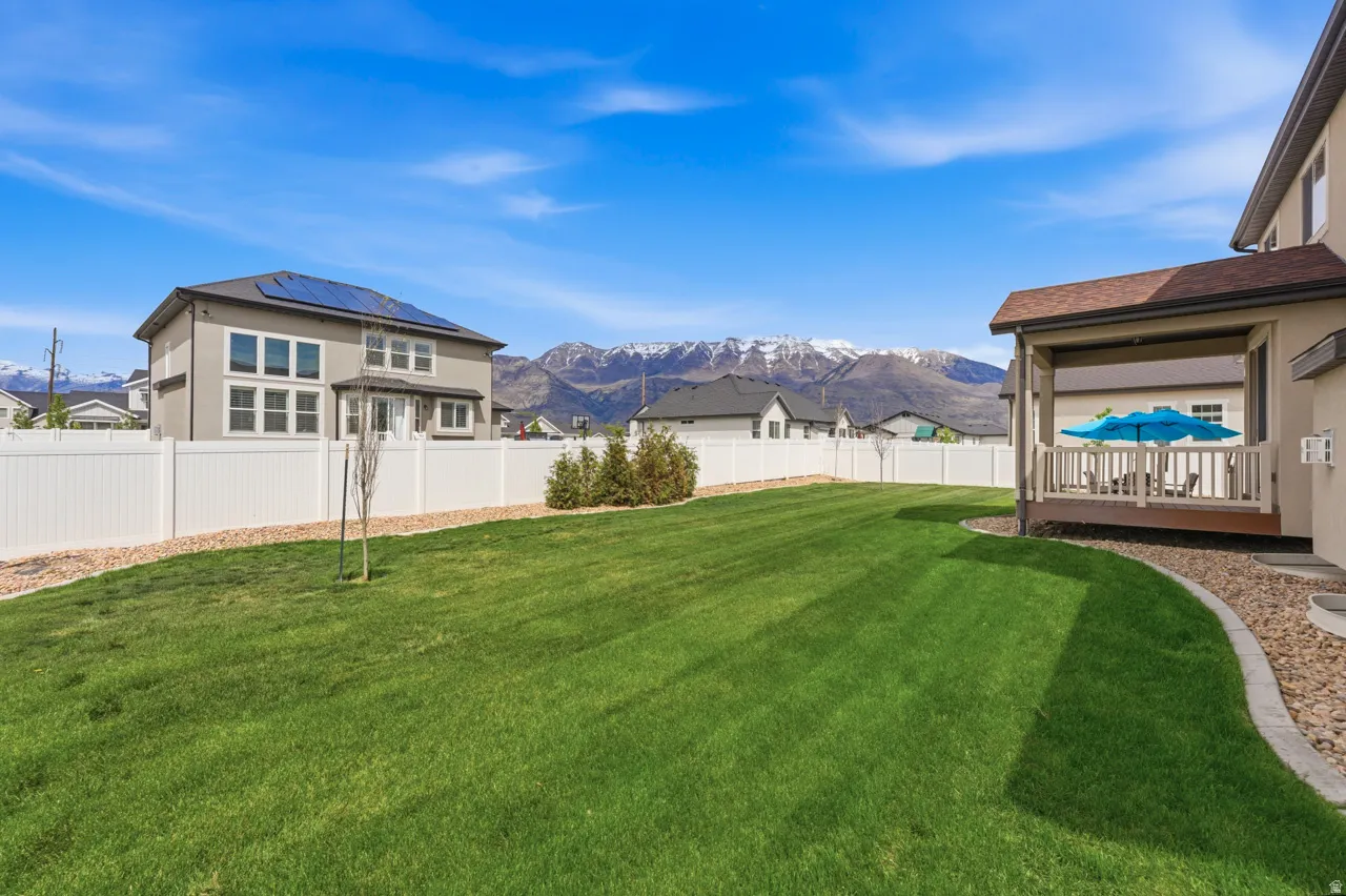 Fenced backyard with a deck with mountain view