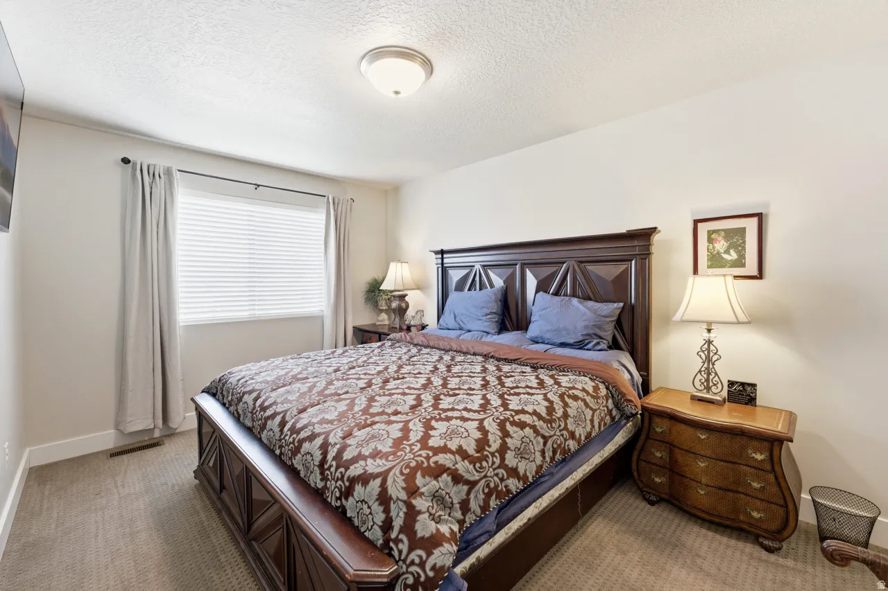 Bedroom with a textured ceiling and carpet floors