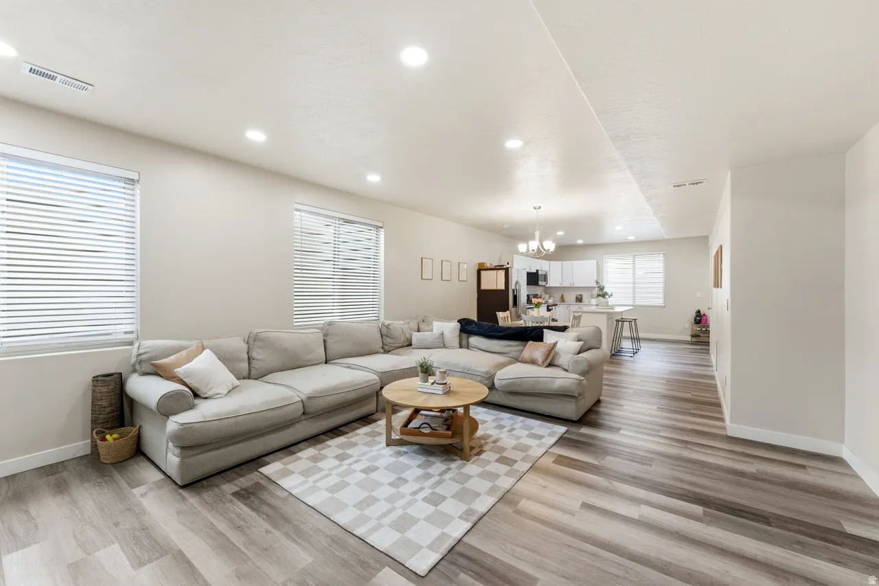 Living area with light wood finished floors and hanging lights