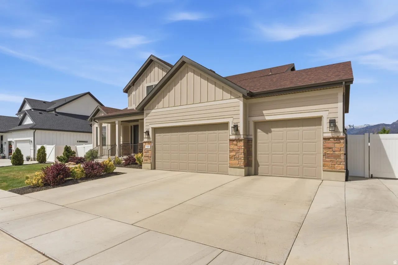 Craftsman house featuring a gate, a garage, board and batten siding, driveway, and a shingled roof