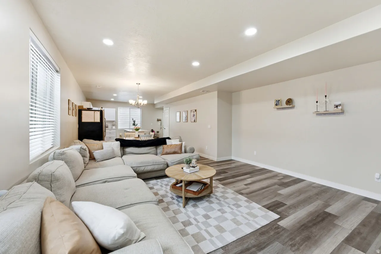 Living room with wood finished floors and suspended lighting