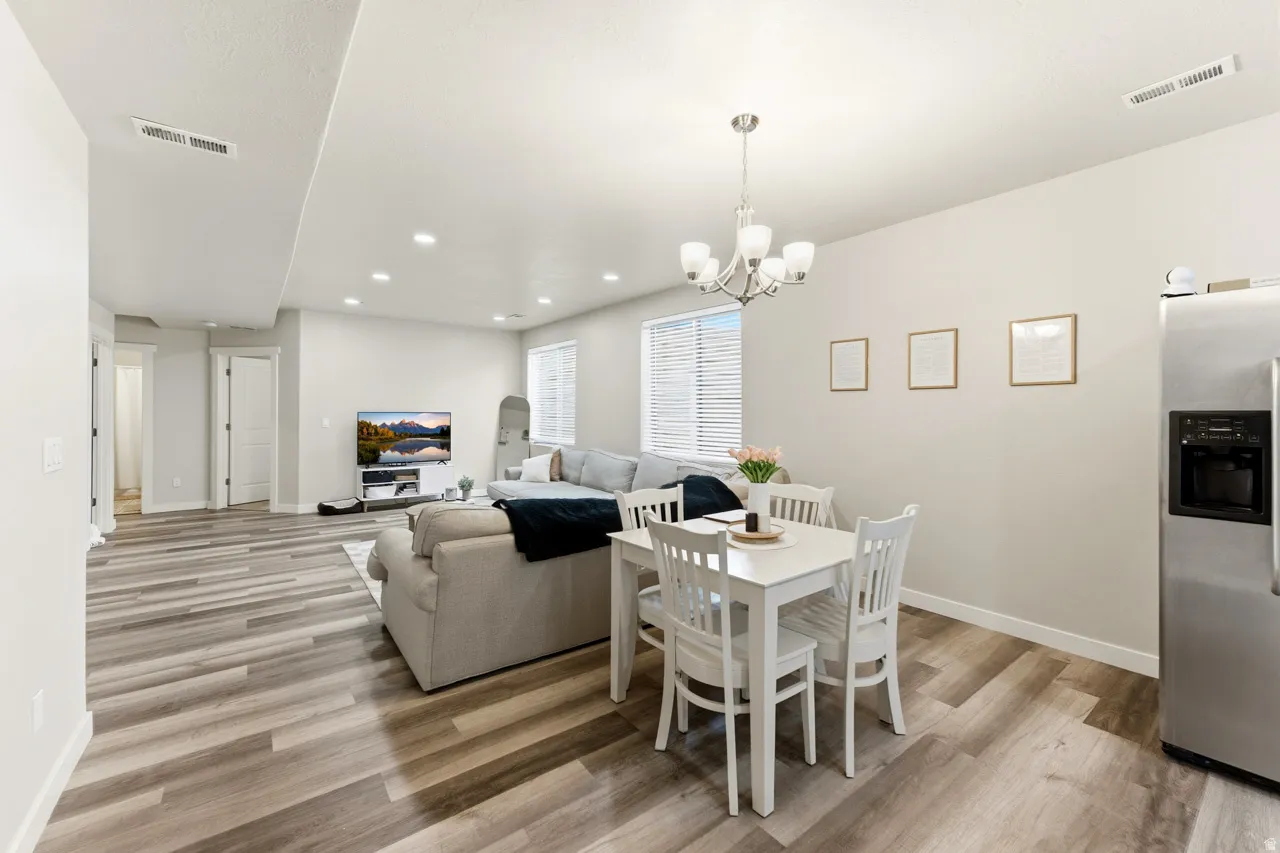 Dining area with light wood finished floors and a chandelier