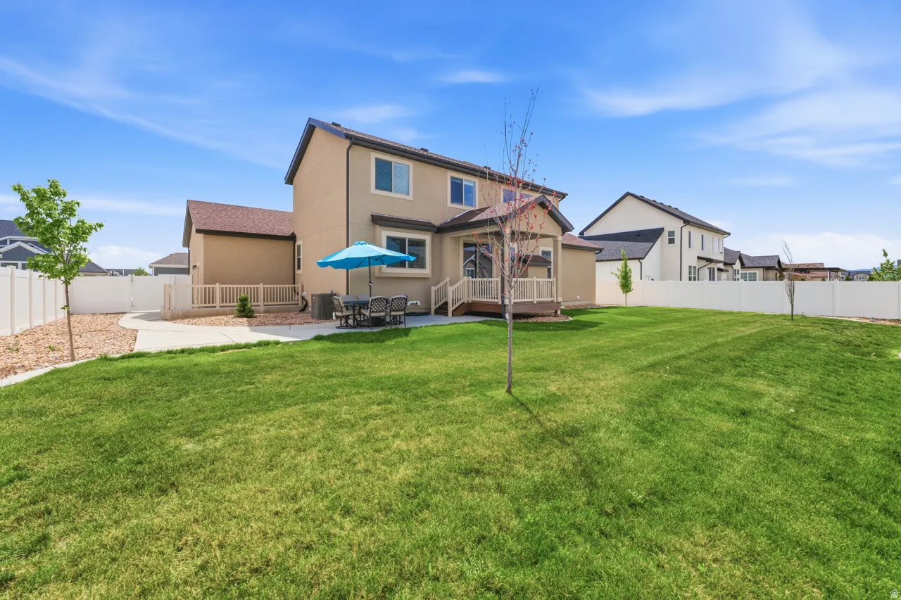 Back of house with stucco siding, a fenced backyard, a patio, and a deck