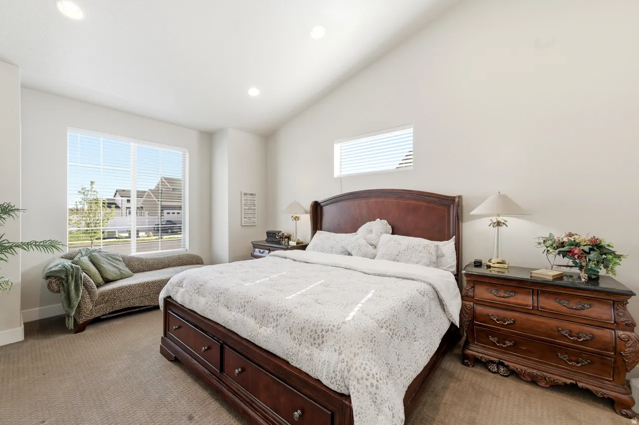 Bedroom with recessed lighting, light carpet, and vaulted ceiling