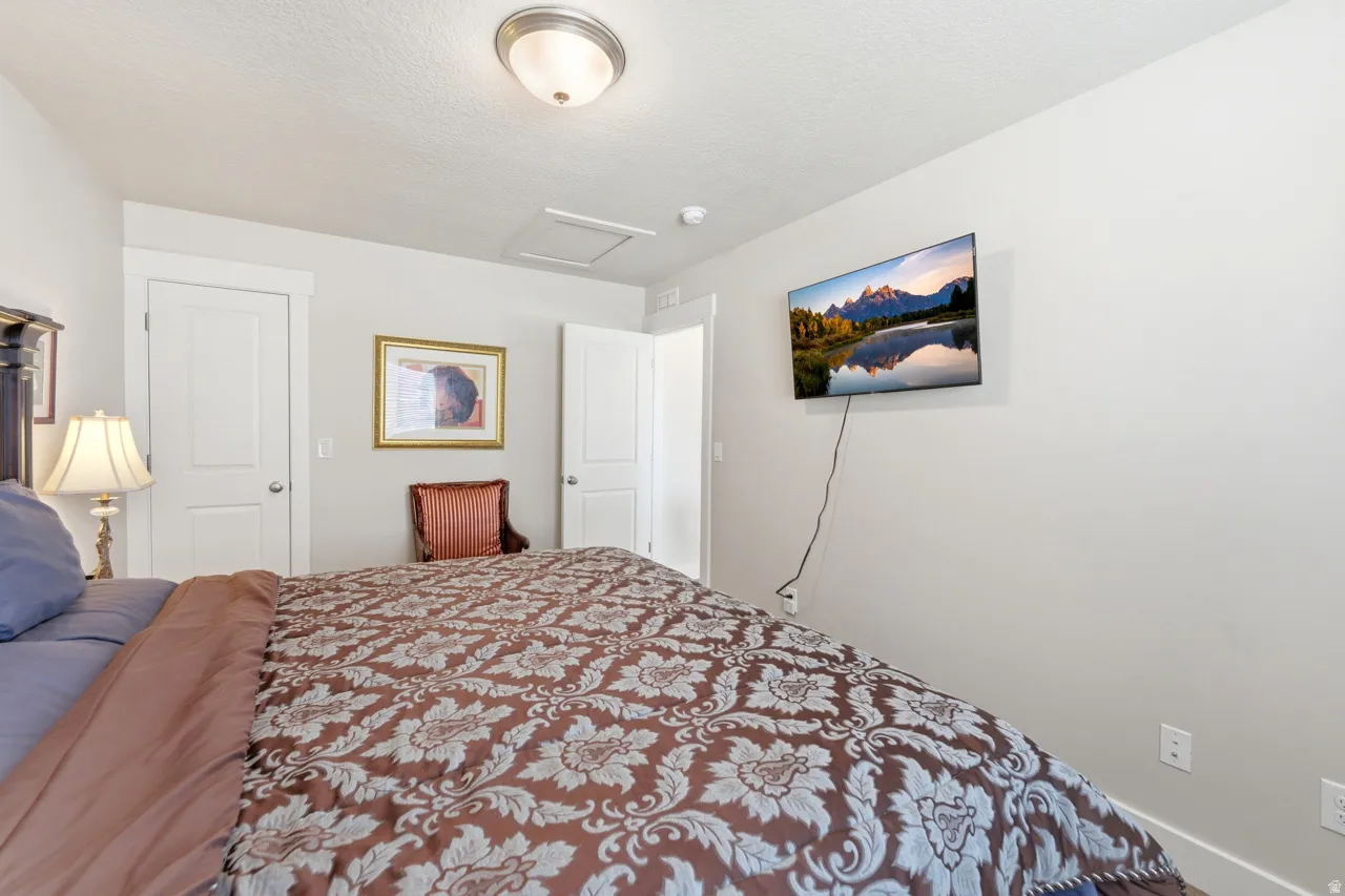 Bedroom featuring attic access and a textured ceiling