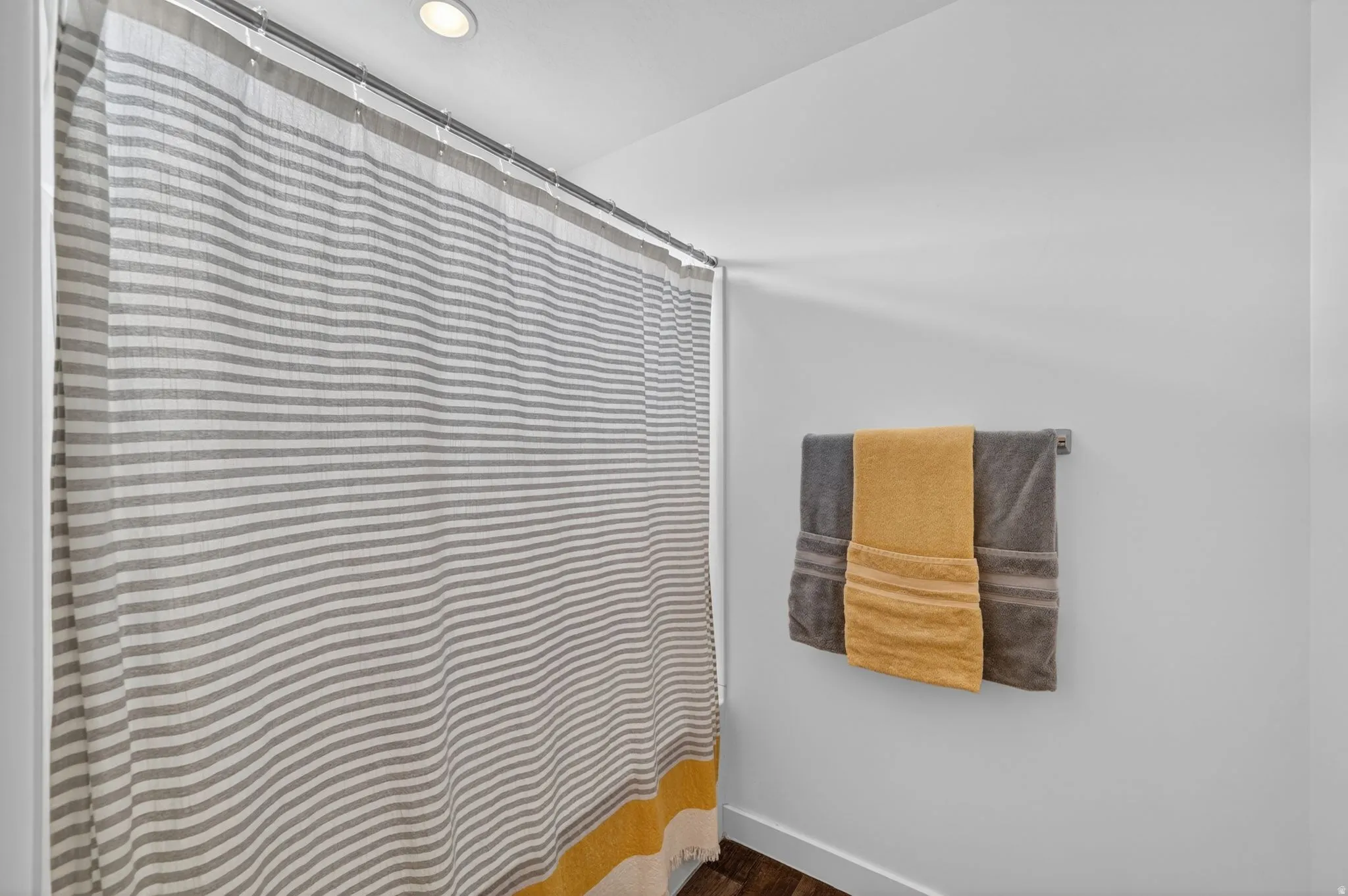 Bathroom featuring a shower with curtain, dark wood-style floors, and recessed lighting