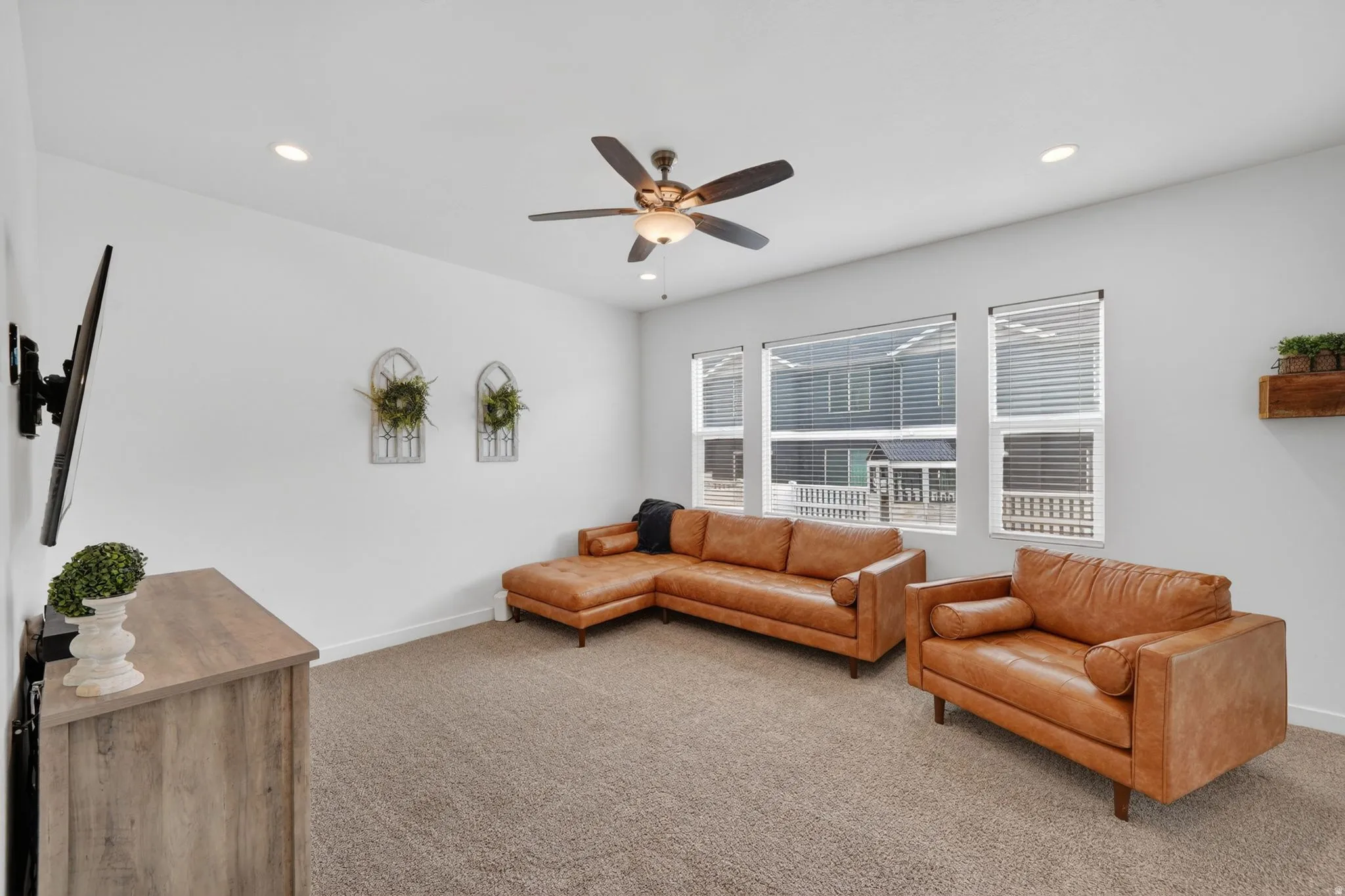 Living area with carpet flooring, recessed lighting, and a ceiling fan