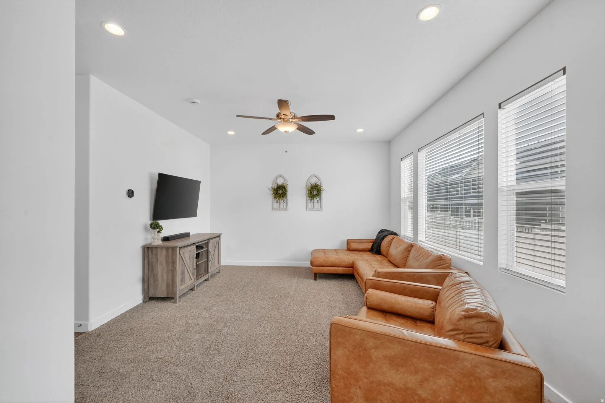 Living area with a ceiling fan, carpet flooring, and recessed lighting