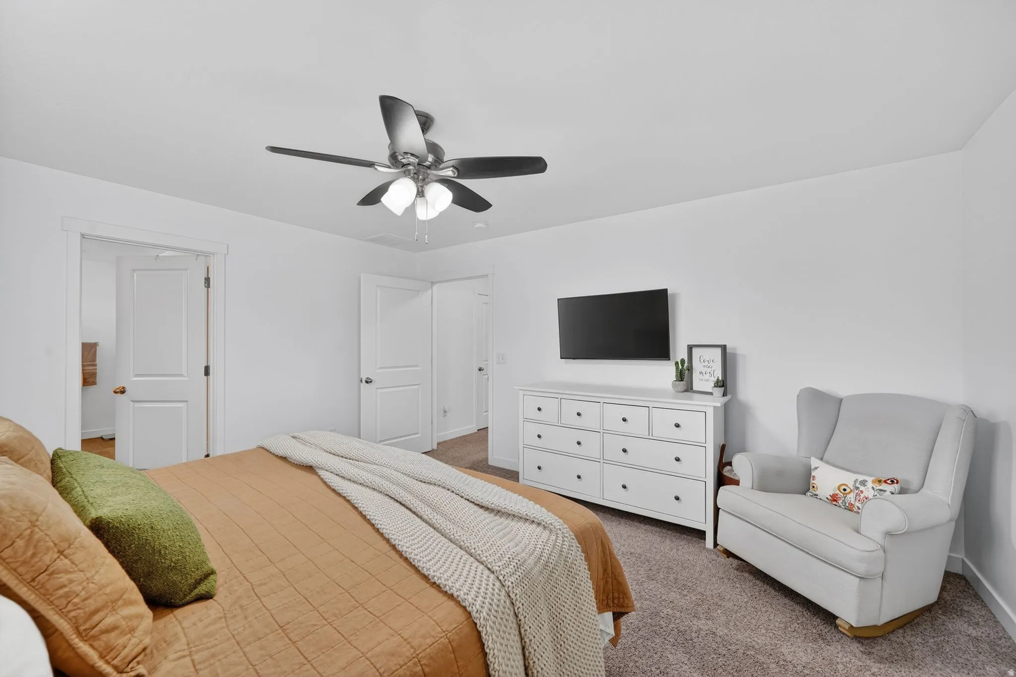 Carpeted bedroom with ceiling fan and baseboards