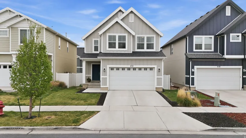 Craftsman house with a garage, board and batten siding, a shingled roof, concrete driveway, and a front yard