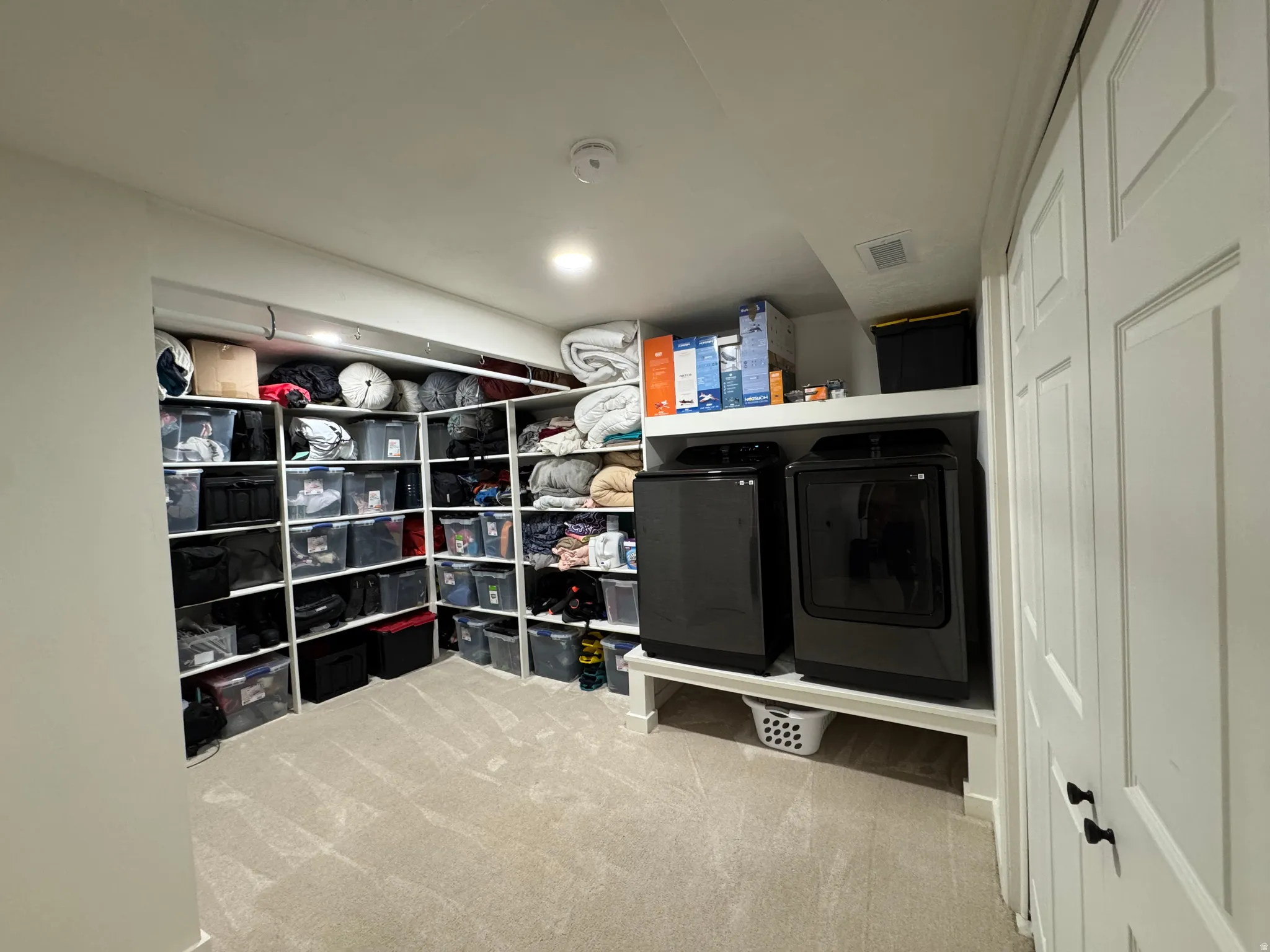 Laundry area featuring light carpet and independent washer and dryer
