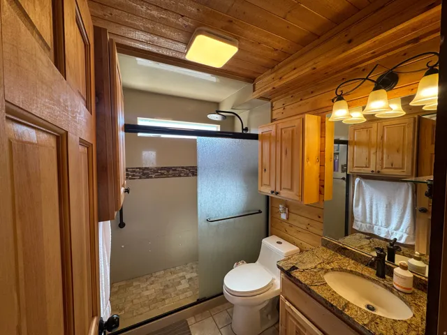 Full bath with vanity, a shower stall, and wood ceiling