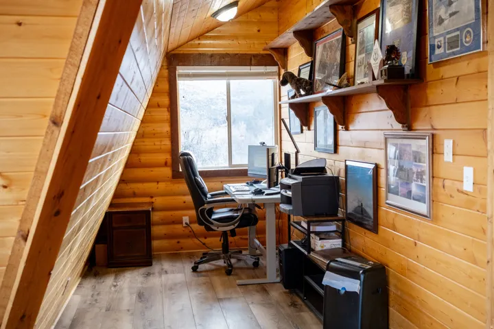 Office area featuring light wood-style flooring, wood walls, and a vaulted wooden ceiling