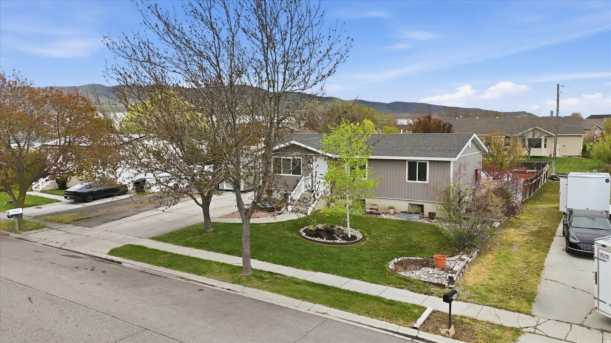 Ranch-style house featuring a mountain view, a residential view, concrete driveway, and roof with shingles