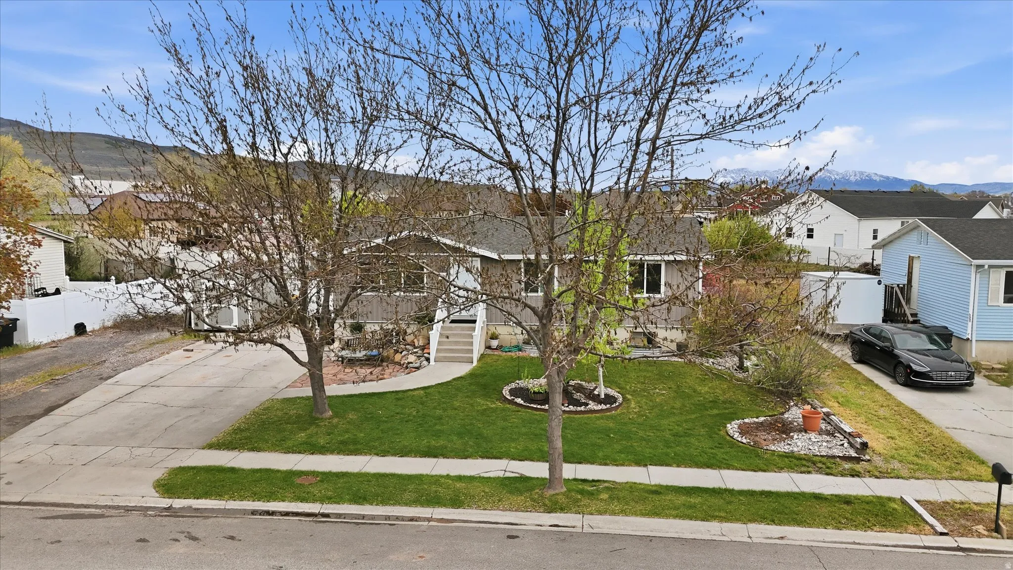 View of front facade with a mountain view, driveway, and a residential view