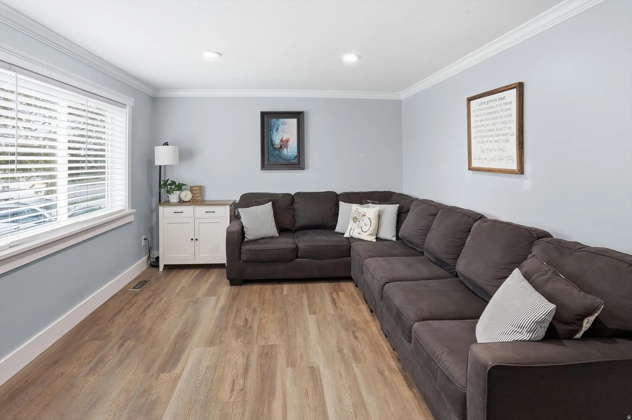 Living room with crown molding and light wood-type flooring