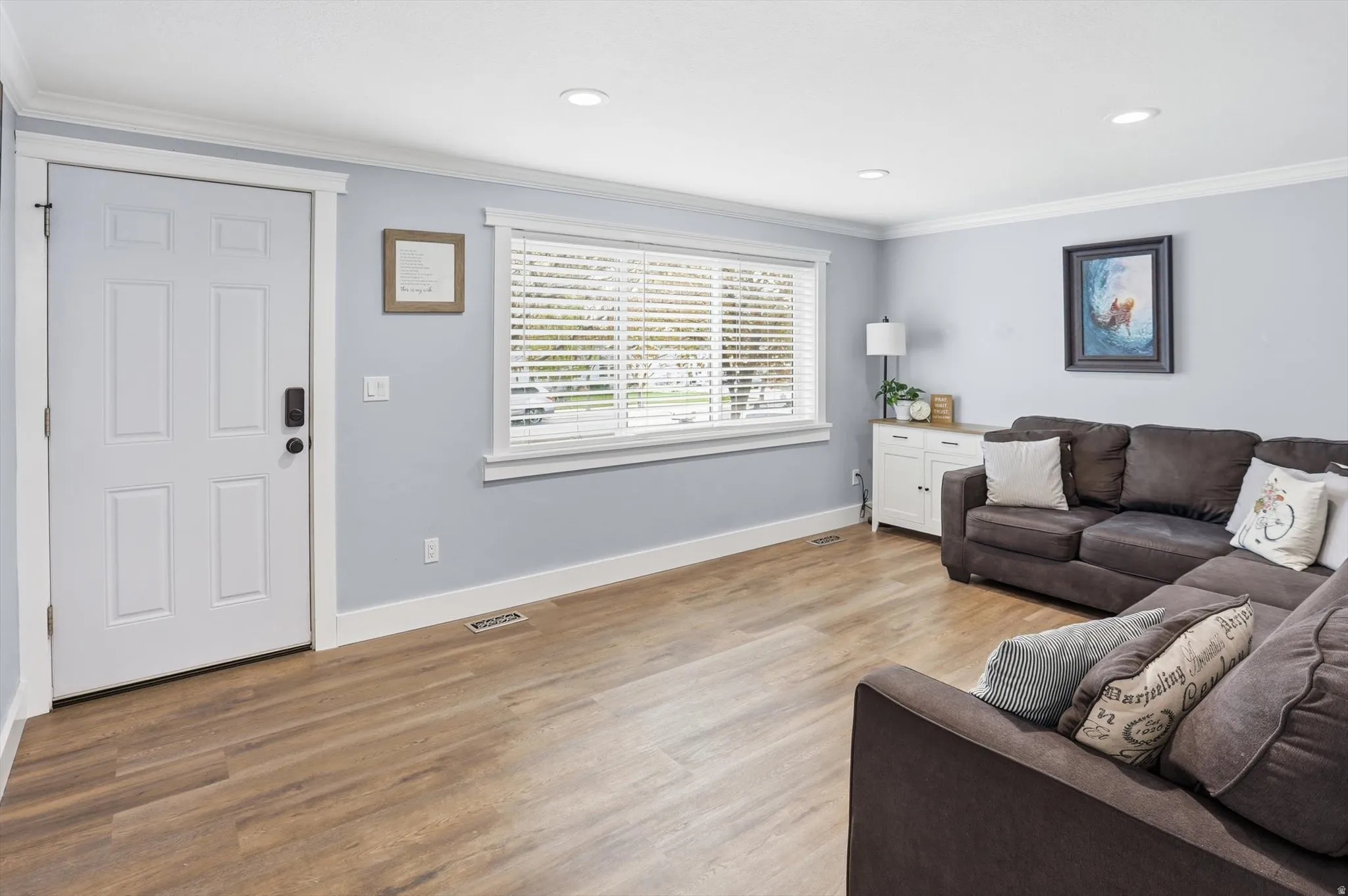 Living area with crown molding, light wood-type flooring, and recessed lighting