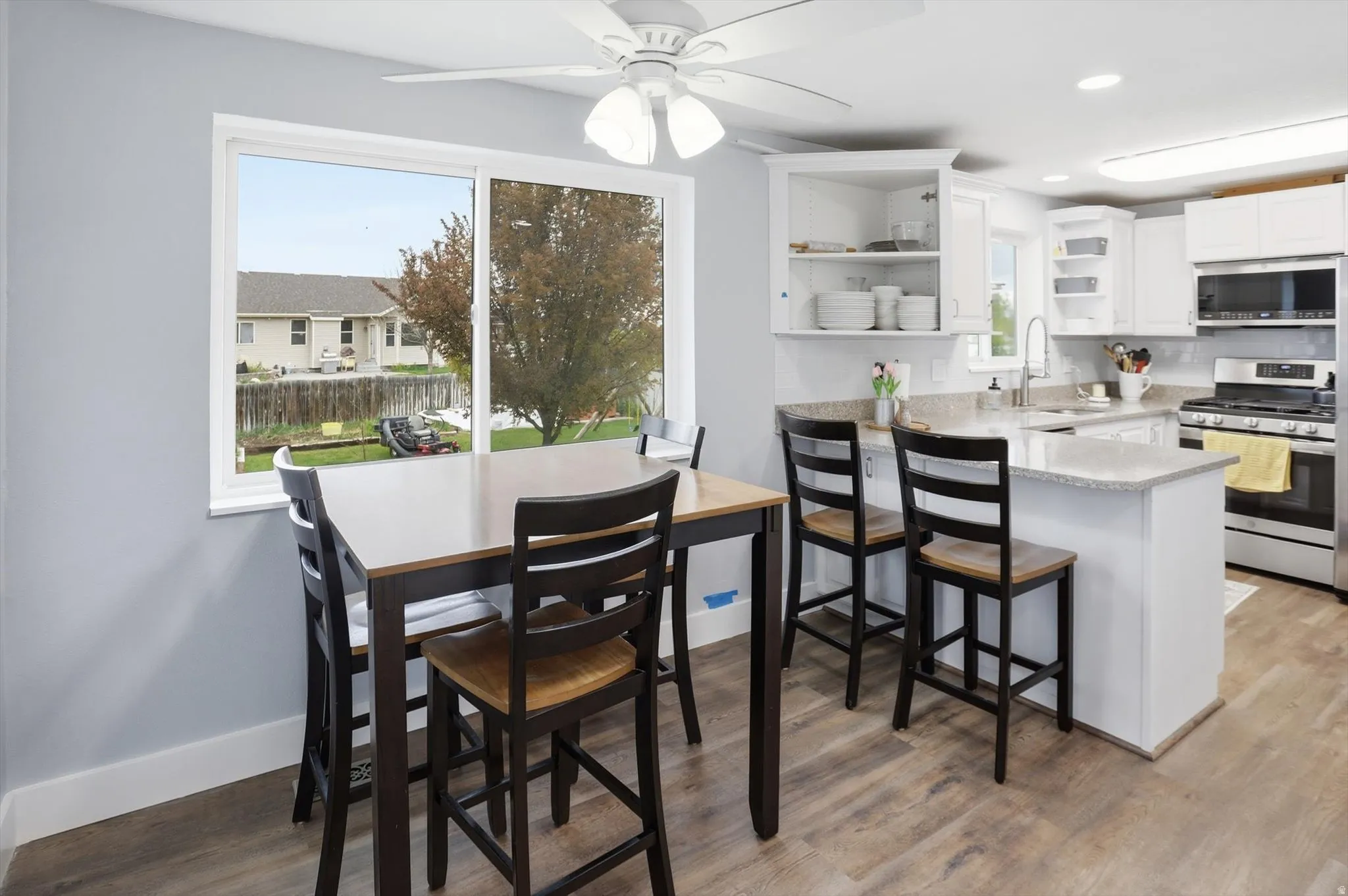 Dining room with a ceiling fan, light wood-style floors, and recessed lighting