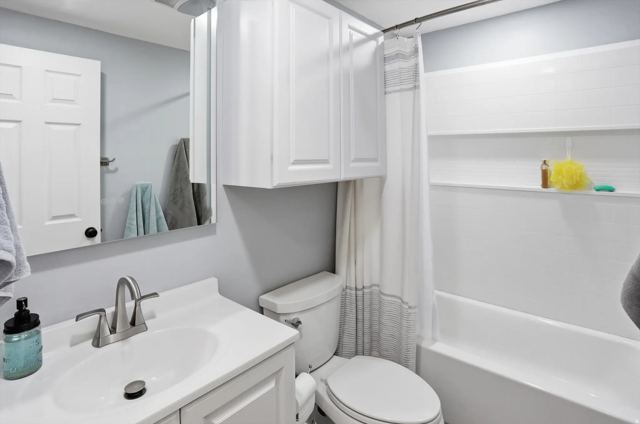 Bathroom with vanity and shower / tub combo with curtain