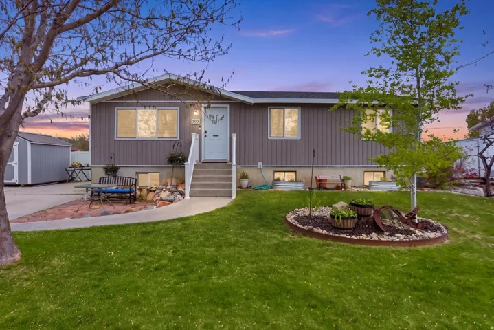 Back of property at dusk featuring a shed, a patio, and a yard