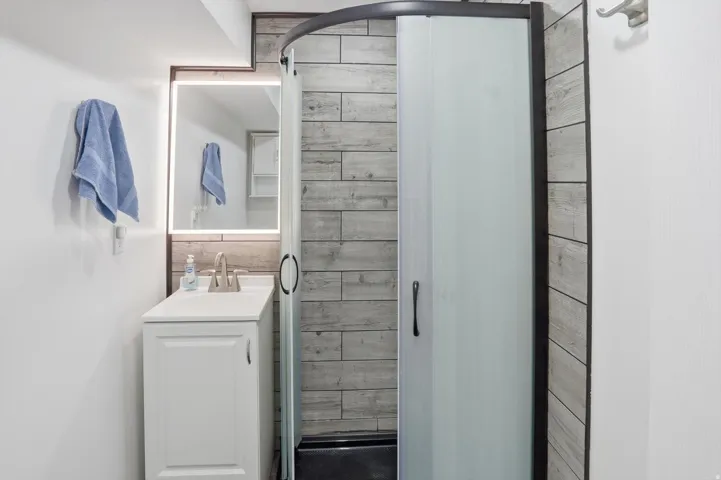 Full bathroom featuring vanity and a shower stall
