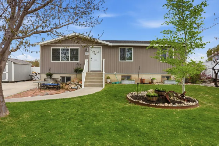 Single story home featuring a storage shed, a front yard, and a patio area