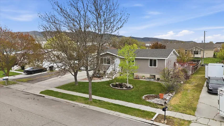 Ranch-style house featuring a mountain view, a residential view, concrete driveway, and roof with shingles