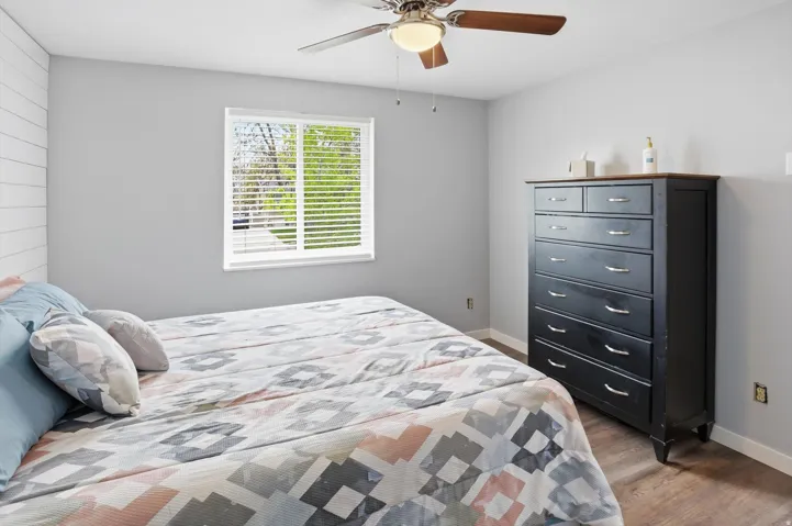 Bedroom with ceiling fan and dark wood-style flooring