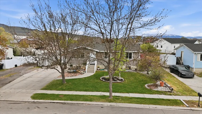 View of front facade with a mountain view, driveway, and a residential view