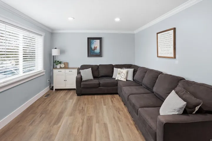 Living room with crown molding and light wood-type flooring