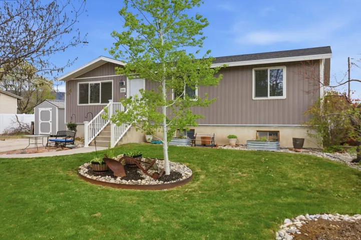 Back of house with a storage shed, a fire pit, a patio area, and a yard