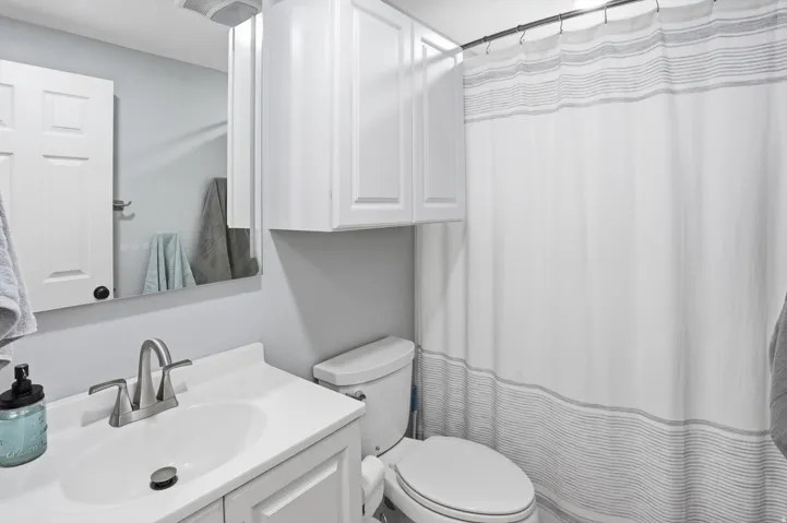 Bathroom featuring curtained shower and vanity