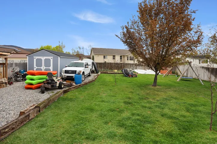 Fenced backyard with a storage unit
