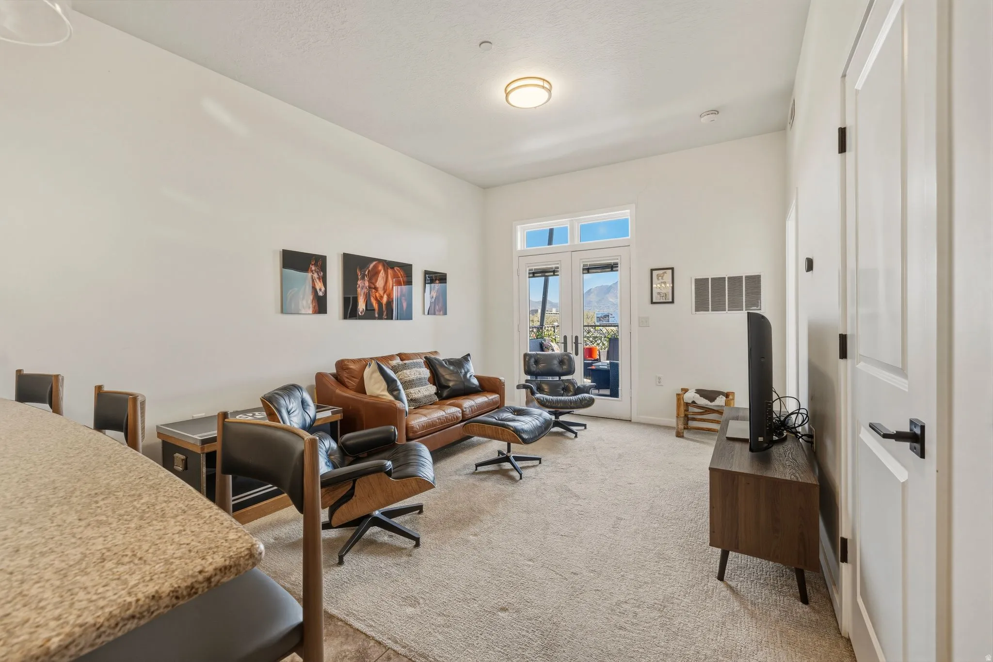 Living area with light carpet and french doors