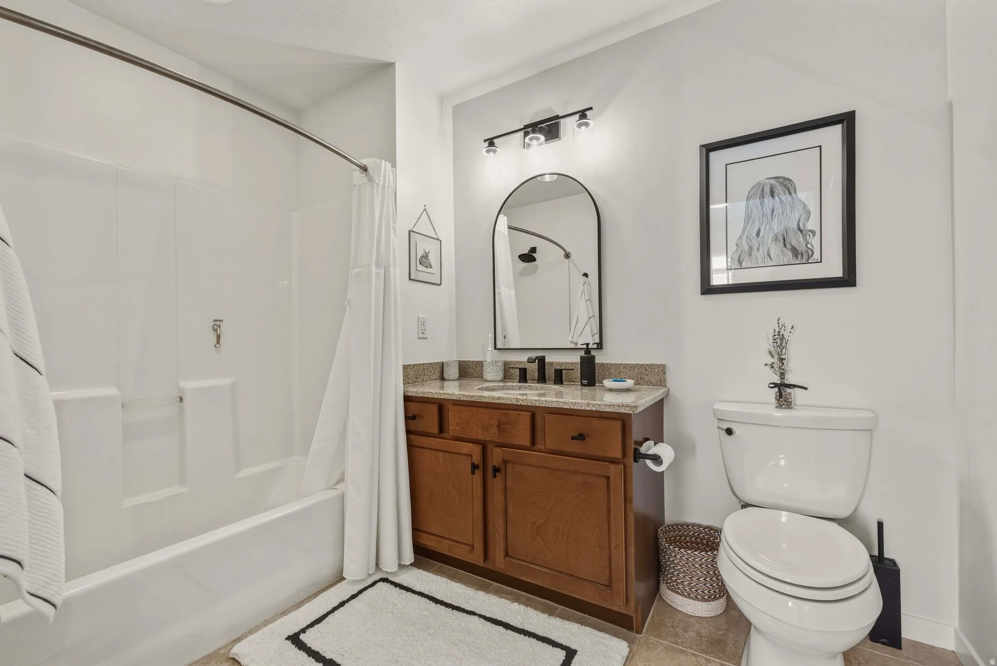 Full bath featuring vanity, shower / bathtub combination with curtain, and light tile patterned floors