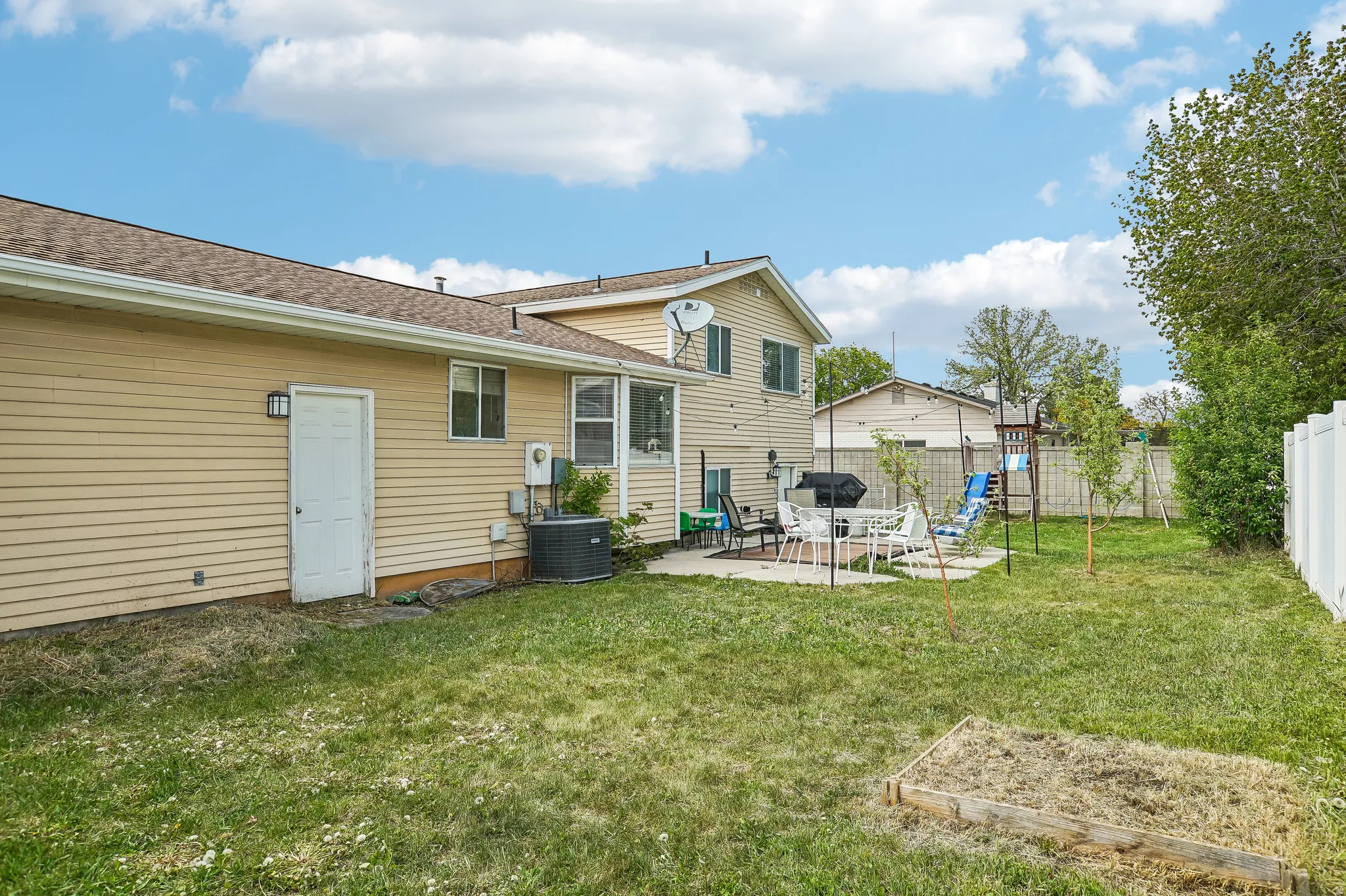 Rear view of house with a patio area, a fenced backyard, roof with shingles, and a playground