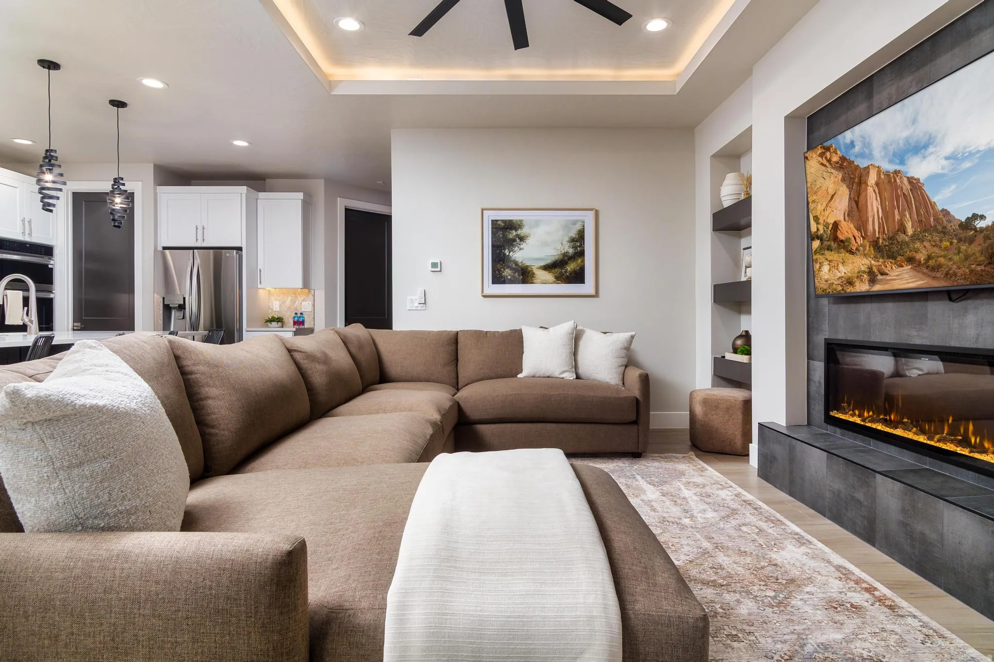 Living room with built in shelves, recessed lighting, a tiled fireplace, wood finished floors, and a ceiling fan