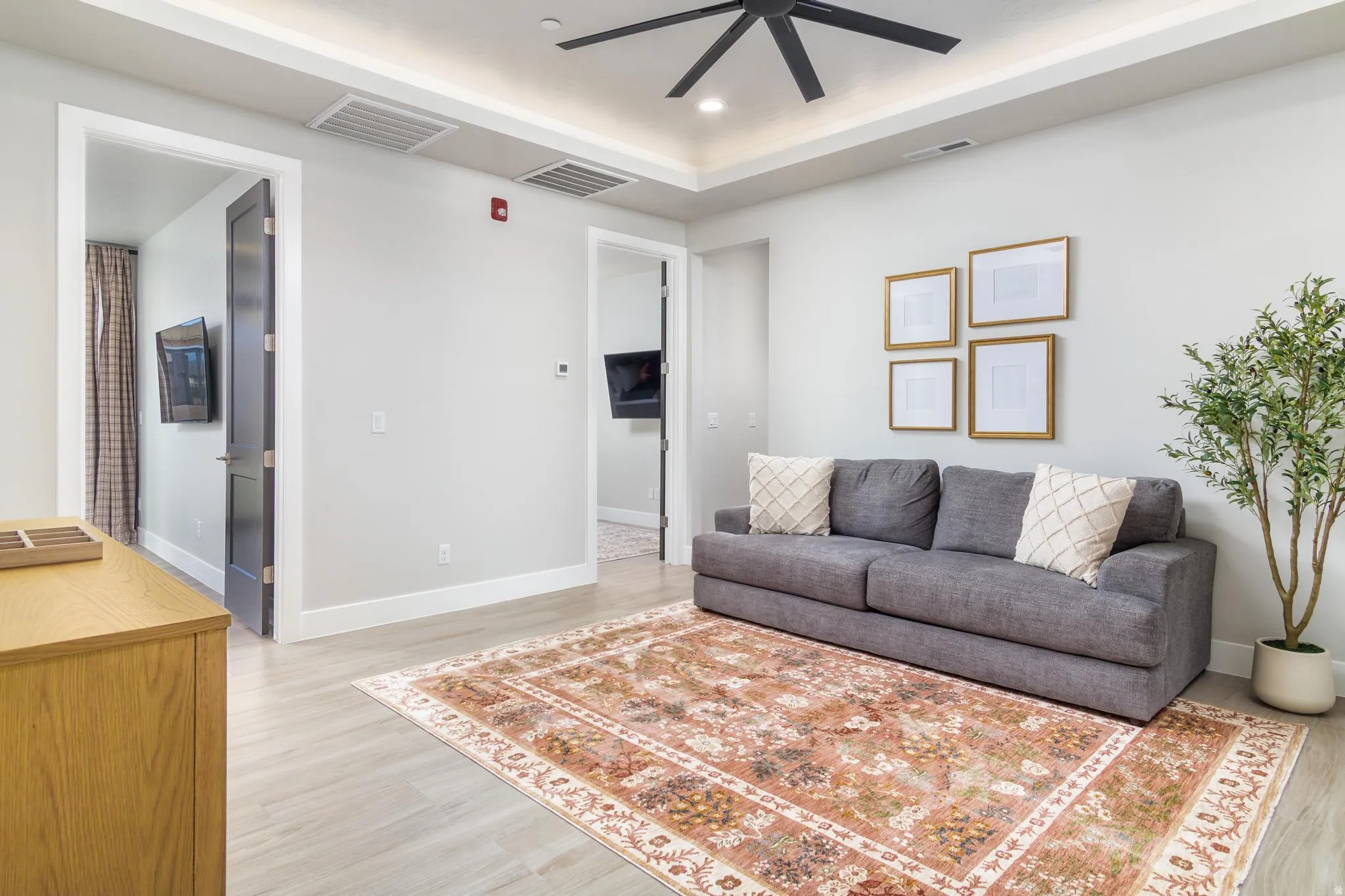 Living room with light wood finished floors, ceiling fan, and recessed lighting