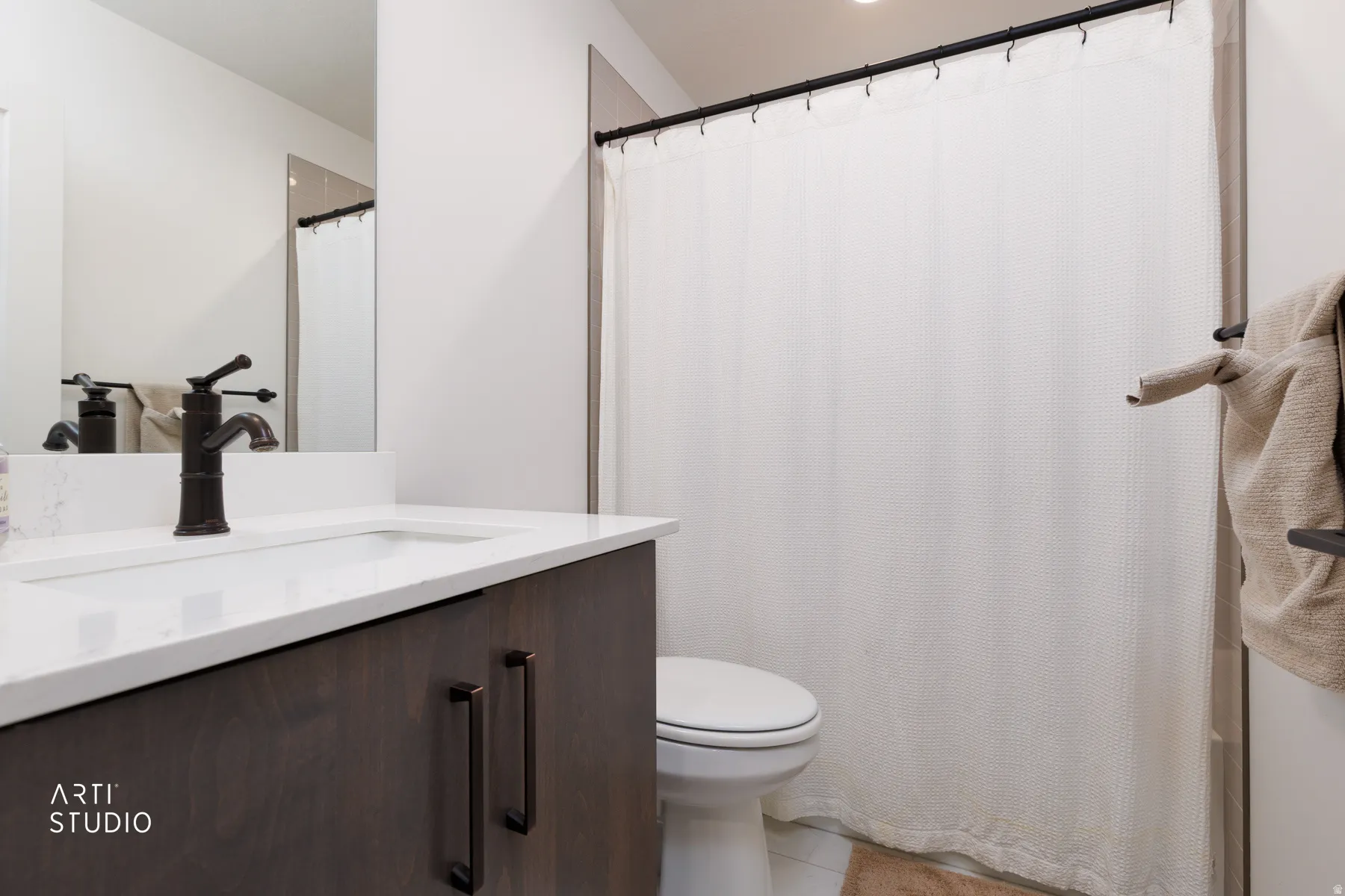 Bathroom featuring vanity, a shower with shower curtain, and light tile patterned flooring