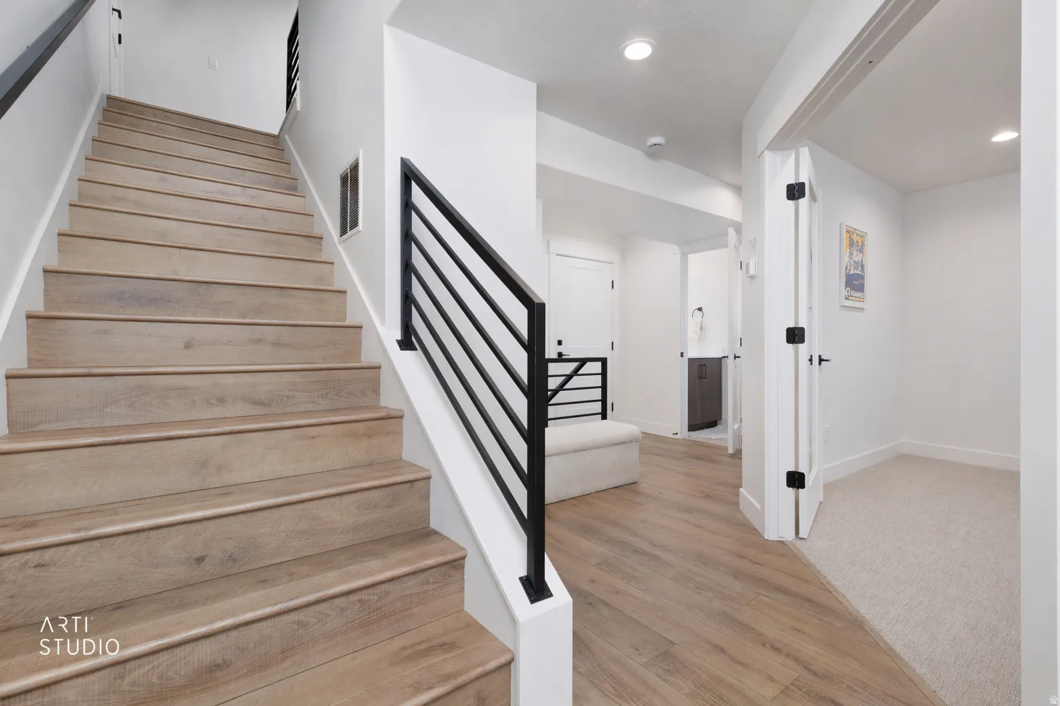 Stairway with wood finished floors and recessed lighting