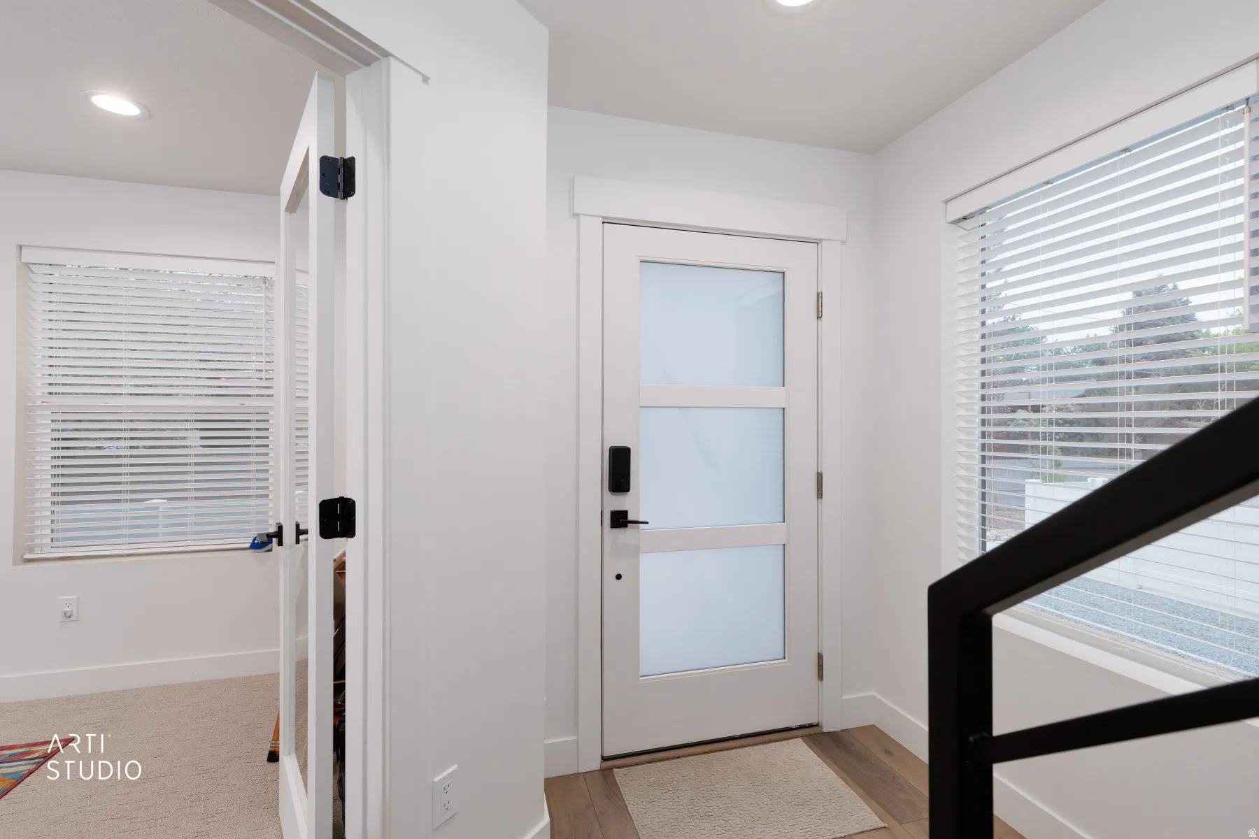 Doorway with wood finished floors and recessed lighting