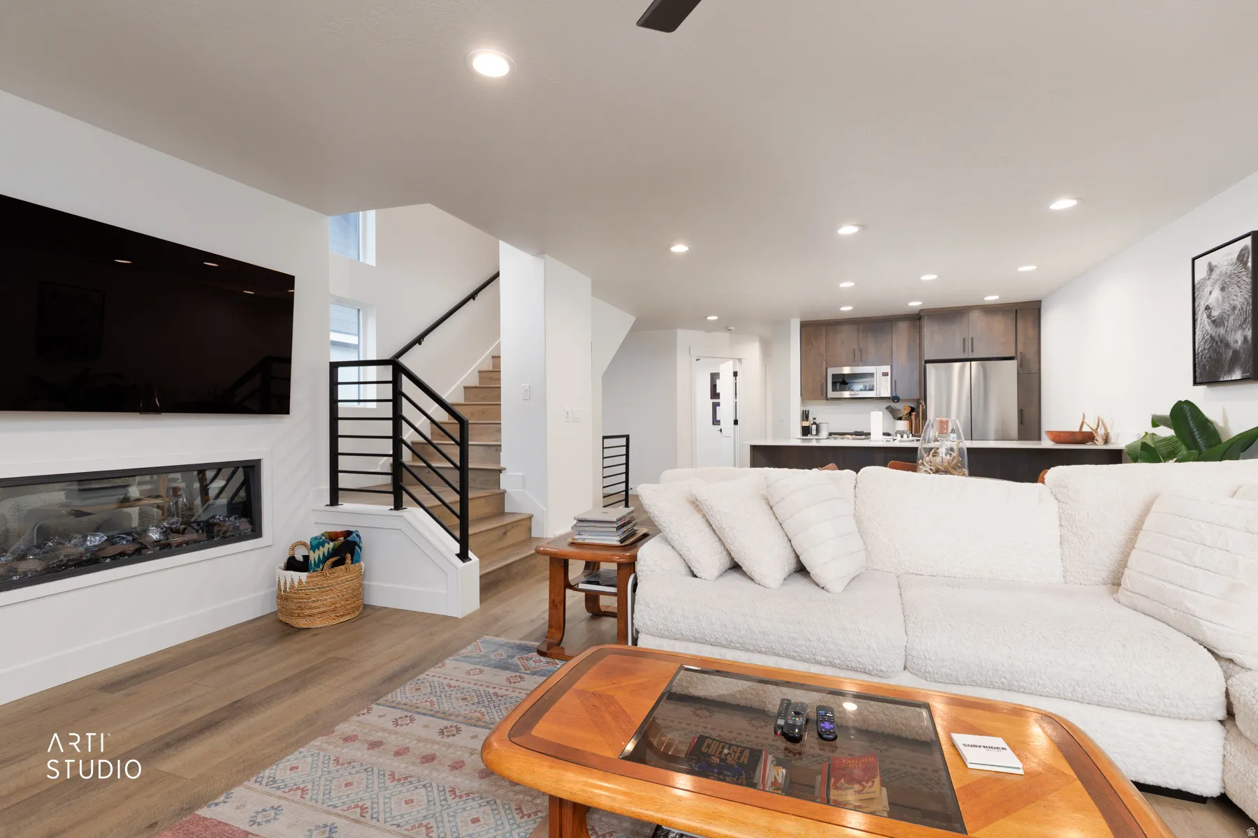 Living area featuring dark wood-style floors, a glass covered fireplace, ceiling fan, and recessed lighting