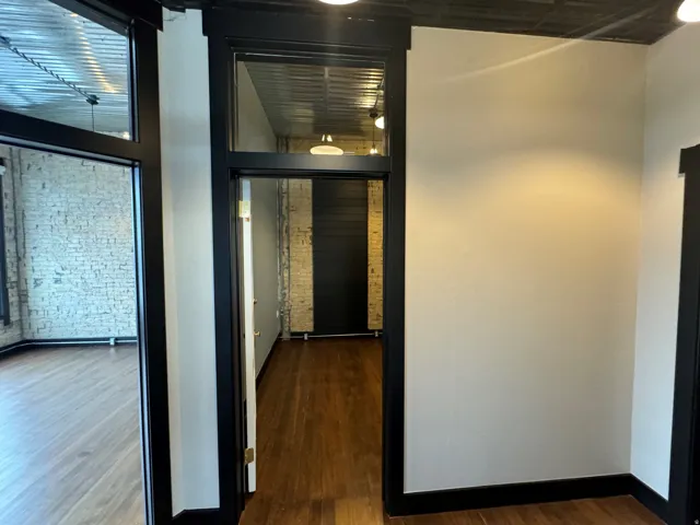 Hall with brick wall and dark wood finished floors