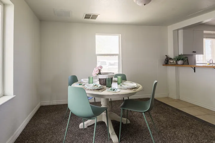 Dining space with baseboards and light carpet