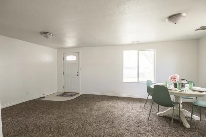 Carpeted foyer entrance with a textured ceiling