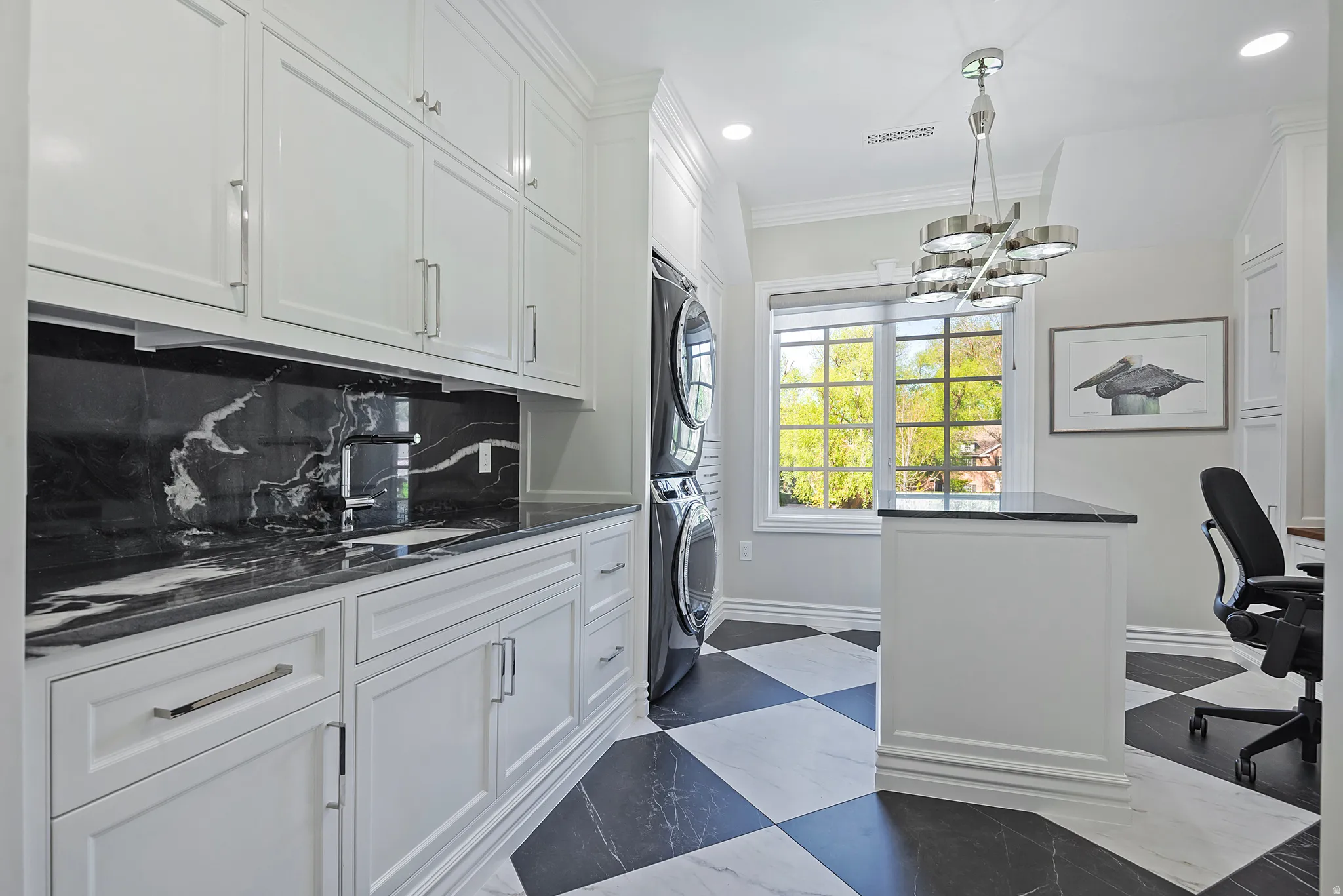 Second Laundry area featuring stacked washer / drying area, crown molding, and suspended lighting, built in cabinetry and desk