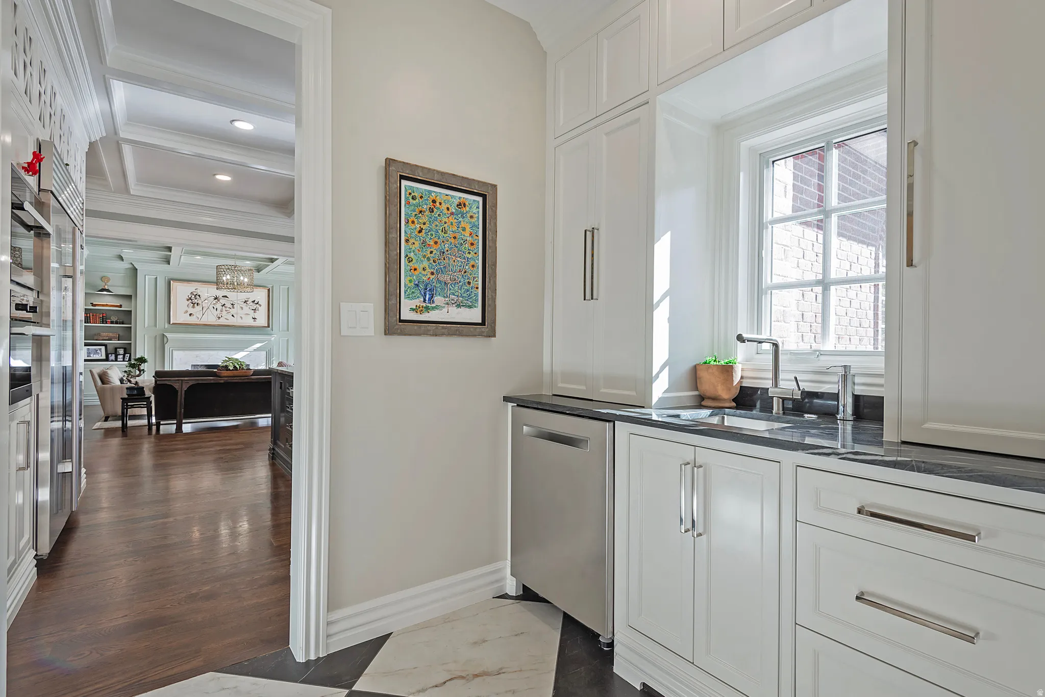 Butlers pantry with cabinetry, extra stainless steel appliances, sink and hidden appliance garages.