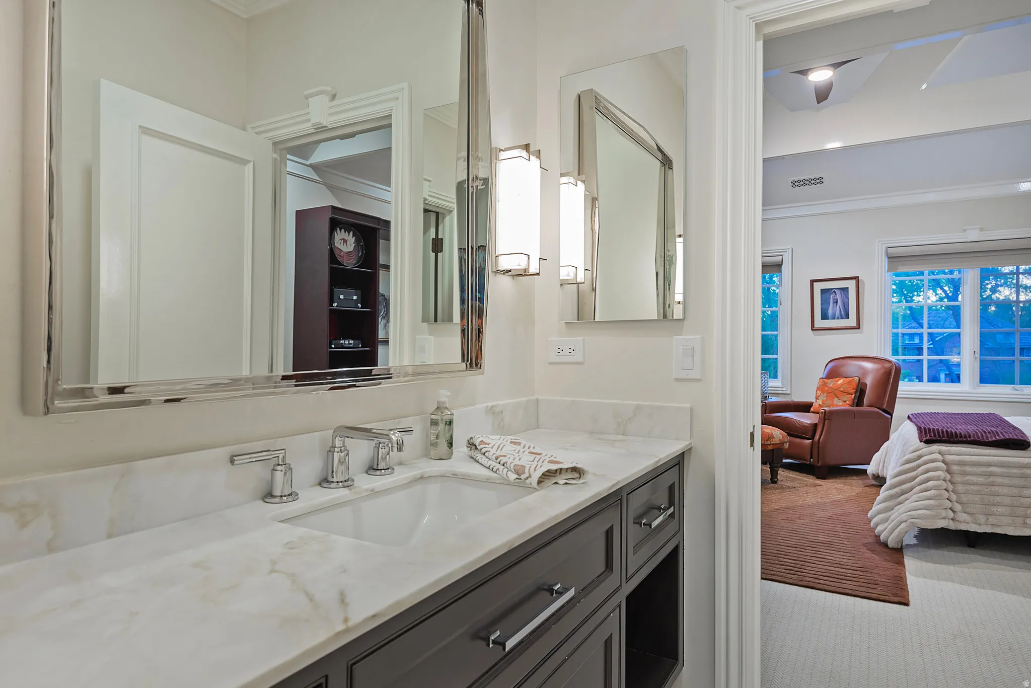 Bathroom featuring ornamental molding, single vanity, and connected ensuite
