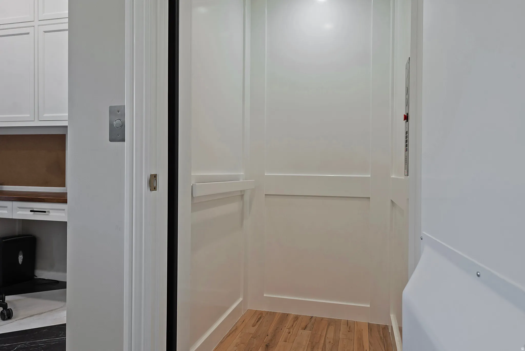 Elevator with wood finished floors and an office area - services 1-2 floors.